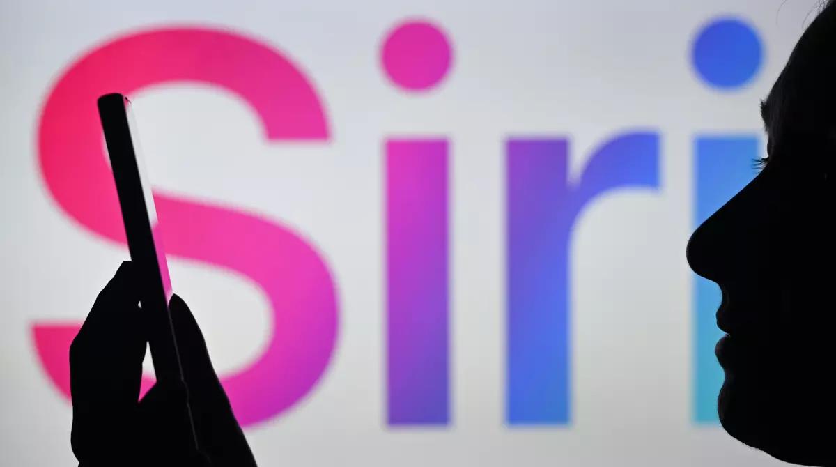 A silhouette of a person holding a phone with pink and blue text in the background saying Siri